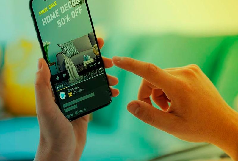 Pessoa tocando para acessar um anuncio de video na tela do celular