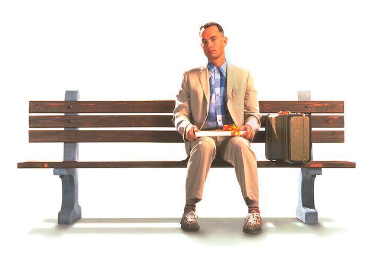 Imagem clássica do filme Forest Gump, com o protagonista sentado em um banco de praça.
